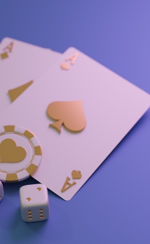 A set of playing cards displaying four aces is laid out on a surface. Alongside them, there are two poker chips with heart and diamond symbols, and three six-sided dice showing different numbers. The background is a smooth gradient of purple, creating a thematic gaming or casino atmosphere.